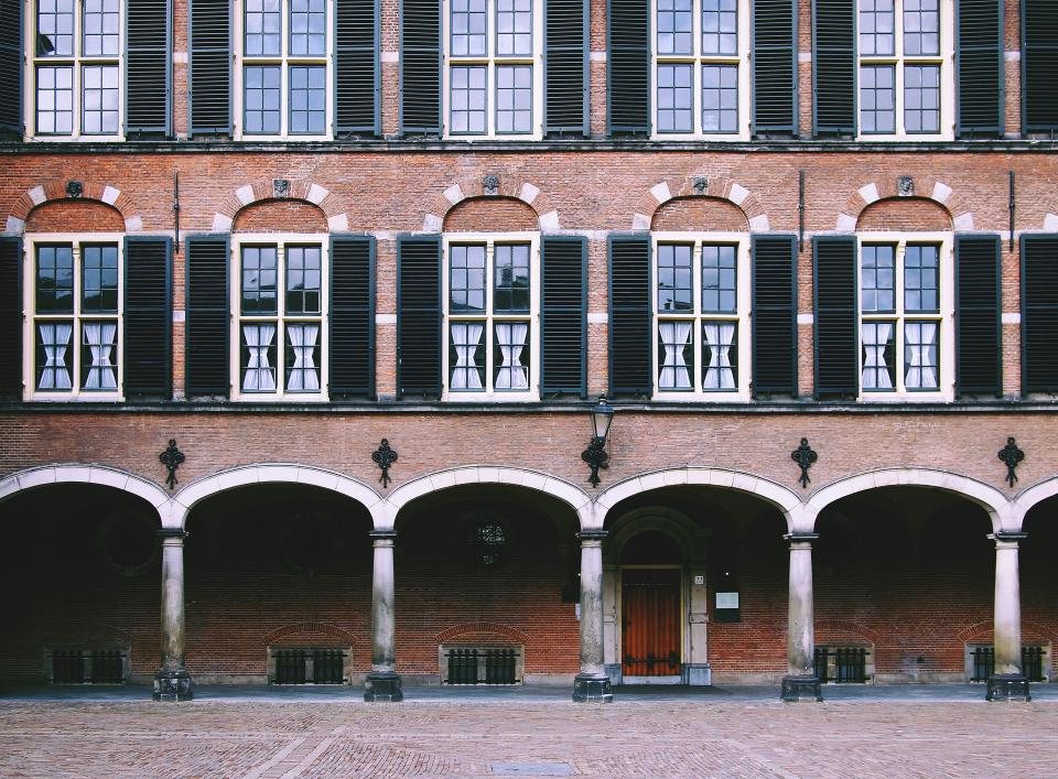 Façade d’un bâtiment public en brique avec arcades
