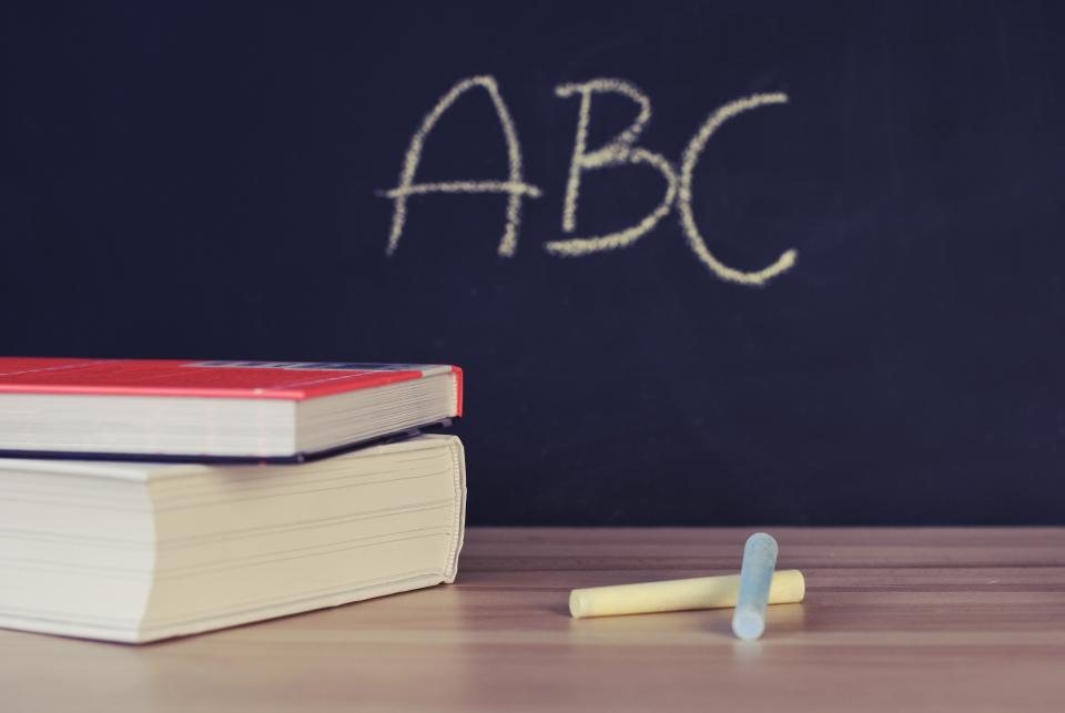 Tableau noir avec les lettres ABC et pile de livres