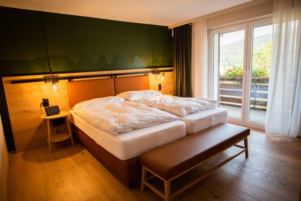 Chambre d’hôtel boisée avec lit double et baie vitrée