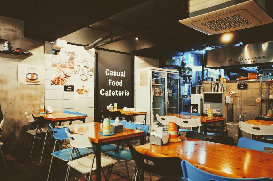 Salle de cafétéria avec tables et comptoir de service